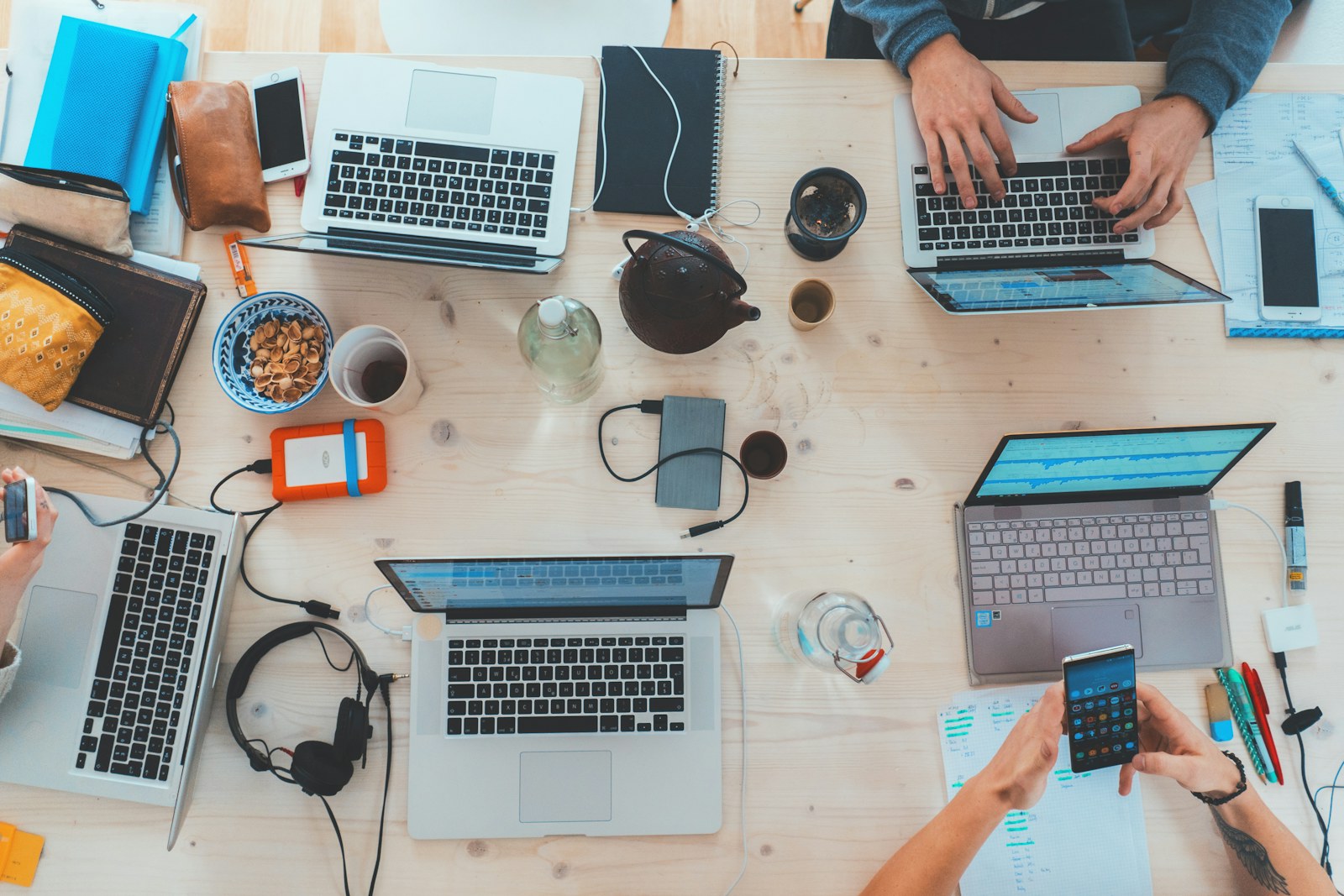 Pessoas estudando e trabalhando com notebooks em uma mesa compartilhada